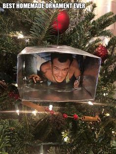 a christmas ornament hanging from the top of a tree with an image of a man on it