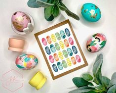 an arrangement of painted eggs and plants on a table