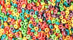 there are many different colored cereals on the table and one is multicolored