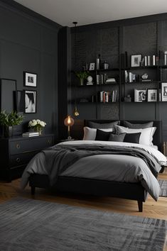 a bedroom with black walls and gray bedding in the center, along with an area rug on the floor