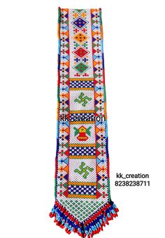 a colorful cross stitched scarf with tassels