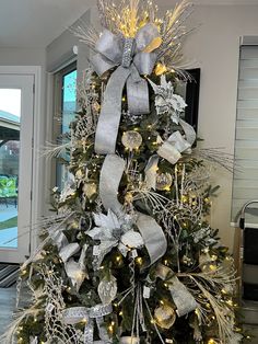 a decorated christmas tree with silver and gold decorations