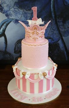 a three tiered cake with pink and white frosting