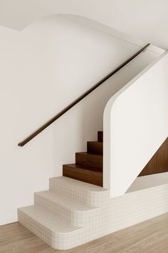 an empty room with white walls and wooden stairs