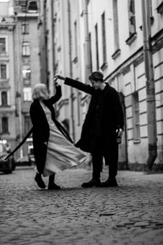 a man and woman are walking down the street with an american flag in their hand