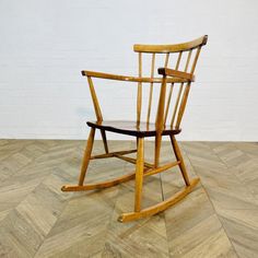 a wooden rocking chair sitting on top of a hard wood floor