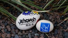 two rocks with the name jehovah painted on them sitting in some gravel