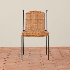 a wicker chair sitting on top of a brick floor