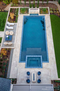 an aerial view of a pool surrounded by lawn furniture