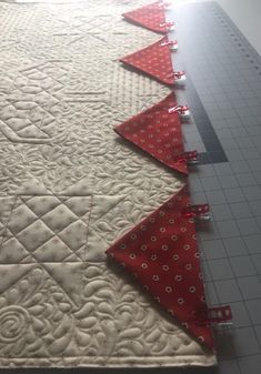 several red and white quilts laid out on the floor next to eachother