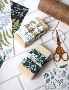 three bars of soap sitting on top of a counter next to scissors and twine