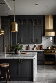 a kitchen with black cabinets, gold accents and marble counter tops is seen in this image