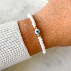 "This listing is for One (1) Evil Eye Bracelet with white glass beads.  Product Details: - Made to Order bracelet - Stretch Bracelet using high quality elastic - Czech Glass Beads (4mm) in White - 14K Gold Filled Bead (4mm) **For gold beads, 14K Gold Filled Beads, they will not tarnish or fade. - 6mm White Evil Eye Bracelet Size: For measurement, you can measure wrist and add 1/2\" for a snug fit (little movement) or add 3/4\" - 1\" for a more loose fit (more movement). **If you need a different size not listed, select any size at checkout and under notes you can let me know the size needed. Reference Size: Small Size - 6.5\" Medium Size - 6.75\" - 7\" Large Size - 7.5\" All bracelets come in a burlap gift bag, perfect for gifting or storing jewelry. To visit my ETSY SHOP: www.etsy.com/sho White Evil Eye Bracelet, White Evil Eye, Burlap Gift Bags, Storing Jewelry, Good Luck Bracelet, Protection Bracelet, Eye Bracelet, Seed Bead Bracelets, Evil Eye Bracelet