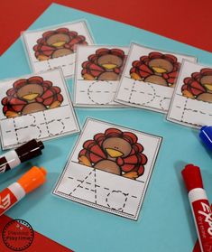 four turkey themed cut outs with markers and marker pens on top of the paper next to them