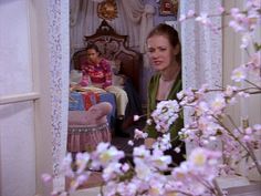 two women sitting in a bedroom with pink flowers