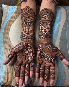 two hands with henna designs on them