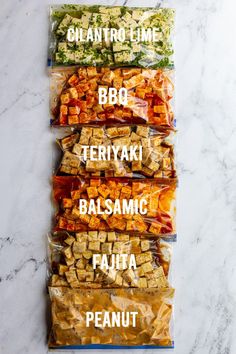 four bags of food sitting on top of a white marble counter next to each other