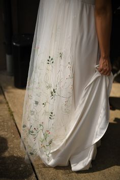 a woman in a white dress walking down the street