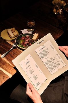 a person sitting at a table reading a menu