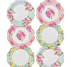 four plates with floral designs on them, one is white and the other has pink flowers