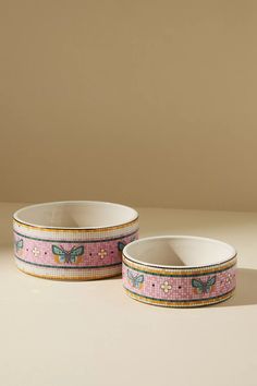 two pink and yellow bowls with butterflies on them