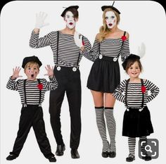 three children dressed up as clowns with their hands in the air and two adults standing behind them