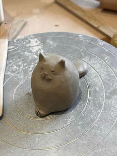 a clay cat sitting on top of a table