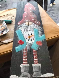 a painted wooden sign with a snowman on it