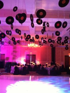 a dance floor is decorated with vinyl records and chandeliers