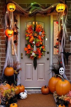 a front door decorated for halloween with pumpkins and decorations