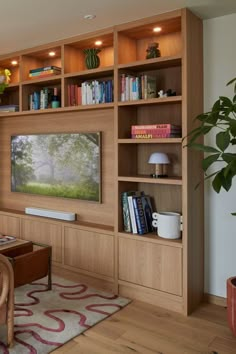 a living room filled with furniture and a flat screen tv mounted on a wall next to a wooden table