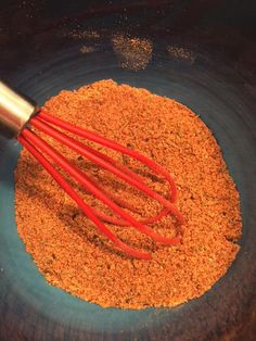 a whisk is in a bowl filled with spices