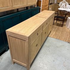 a large wooden cabinet sitting in a room next to other furniture and decor items on display