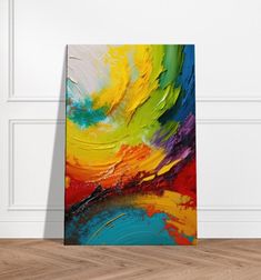 an abstract painting is displayed on the wall in front of a wooden floor and white walls