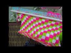 a close up of a pink and green blanket on a rack with toothbrushes