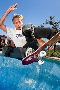 a man riding a skateboard up the side of a swimming pool