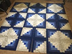 a blue and white quilt is laying on the floor