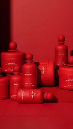 several red containers are stacked on top of each other in front of a red wall