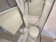 an overhead view of a toilet and shower in a small bathroom with white curtained walls