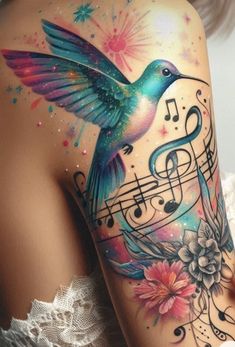 a woman's back with music notes and a humming tattoo on her left shoulder