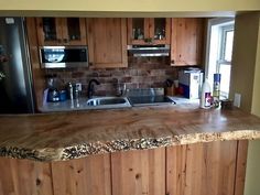 a kitchen with wooden counter tops and stainless steel appliance on the wall next to the sink