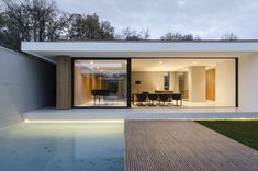 a modern house with an outdoor pool and dining room in the back ground, at dusk