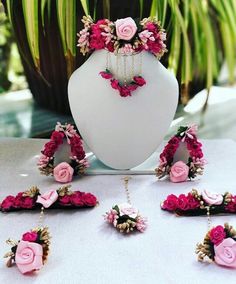 pink flowers and chains are on display in front of a white mannequins