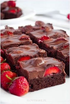 chocolate brownies with strawberries on a white plate