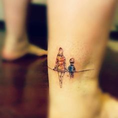 a small tattoo on the ankle of a woman and child