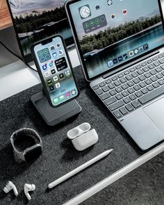 an open laptop computer sitting on top of a desk next to a pair of headphones