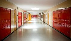 a long hallway with red and yellow lockers