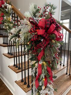 christmas decorations on the banisters and stairs in a home with red bows, pineconis, fir cones and lights