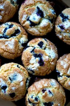 blueberry muffins in a box with powdered sugar on top, ready to be eaten