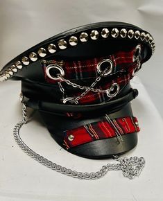 This is a black leatherette captain hat. Well made to a high standard. It has plenty of eye catching detail including metal studs, safety pins and tartan trim  , please refer to photos . It also has a metal chain, This is a size 59 cm which fits most size heads. No two hats are created the same. Individual and unique  Thank you for looking Adjustable Black Punk Costume Accessories, Punk Mini Hats For Halloween Cosplay, Black Punk Costume Accessories, Adjustable Black Mini Hats For Cosplay, Punk Brimmed Costume Hats And Headpieces For Costume Party, Adjustable Punk Costume Hats And Headpieces For Cosplay, Black Punk Costume Hats And Headpieces, Punk Style Adjustable Costume Hats For Cosplay, Punk Winter Hat For Festivals